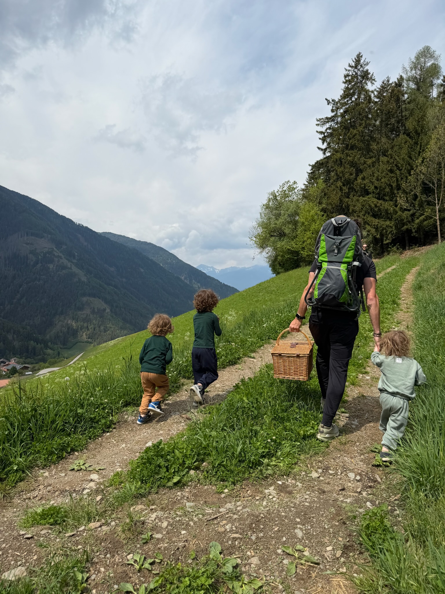 Chris hiking with three boys on a Dolomites trail with picnic basket